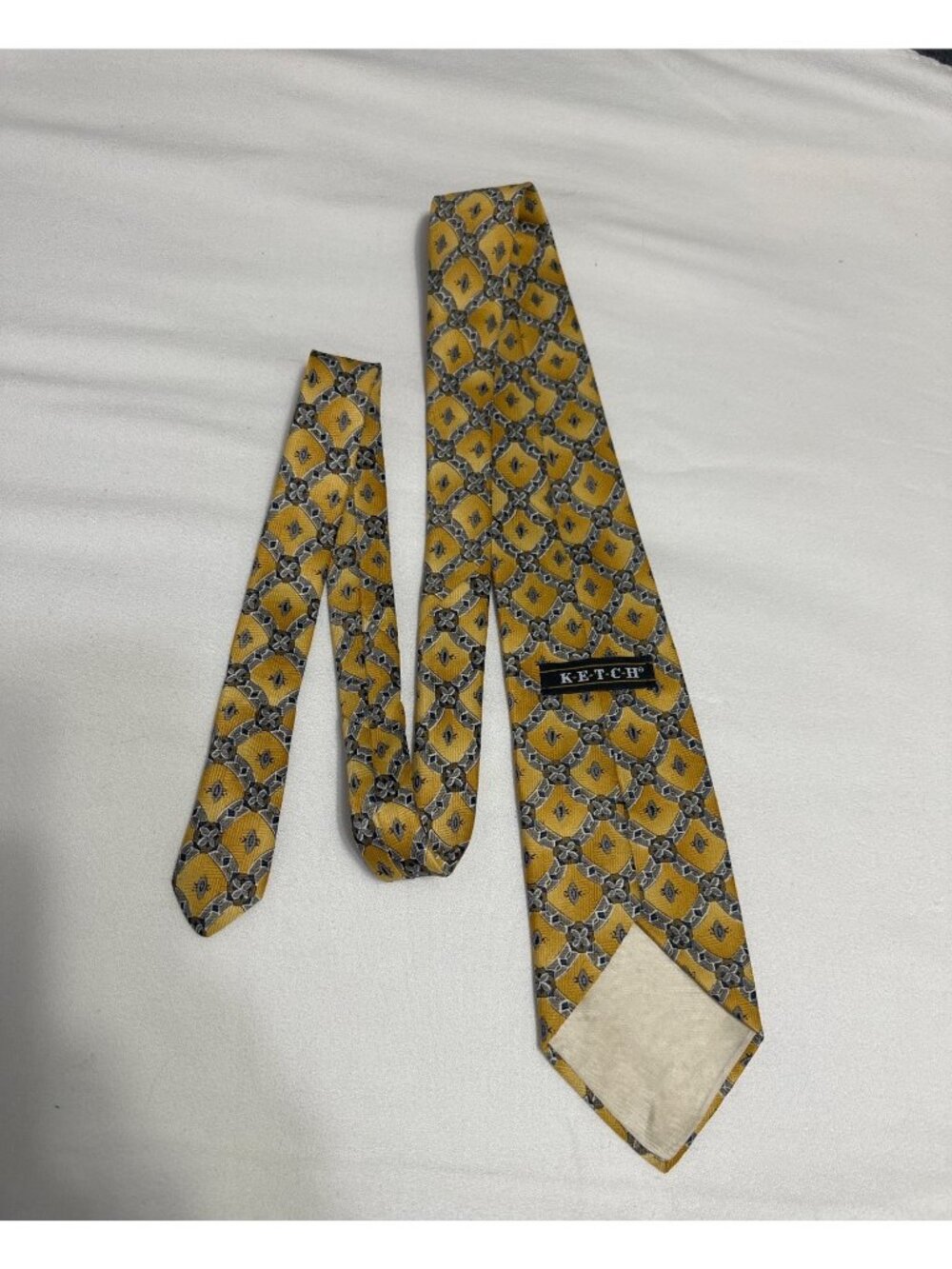 This is a vintage Ketch geometric medallion silk necktie, featuring a distinct g